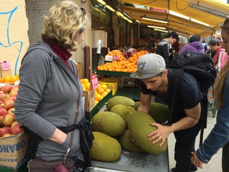 Joan looks on as a strapping young fellow hefts a jackfruit for his lady.