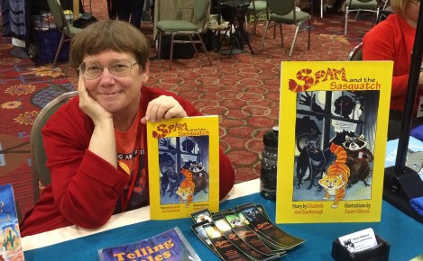 Me, proudly (or maybe smugly) showing off my proof copy of Spam and the Sasquatch at the artists' alley table at A-Kon in Dallas.