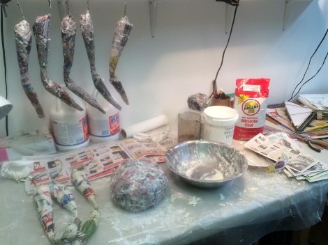 I had forgotten how nice it is to work with flour paste. I used warm water like Dan recommends, and it feels very nice and smells nice too. Here are the spider bits all covered in several layers of paper and glue, laid out and hung up to dry. And the mess. I really had a great time being messy today!