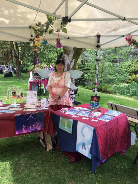 Mariesa and her wares: comics, flower fairy cards, and flower fairy ornaments.