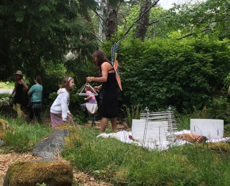 There was a woman playing various instruments made of glass: a sort of harp-like arrangement of glass tubes , three different sizes of milky-glass singing bowls, and a pyramid like object that she would put over people's heads and strike gently. Mesmerizing sounds, especially in the woodland glade setting! (I love the bit of accidental forced perspective in this photo — looks like there is a little girl coming from the pyramid!)